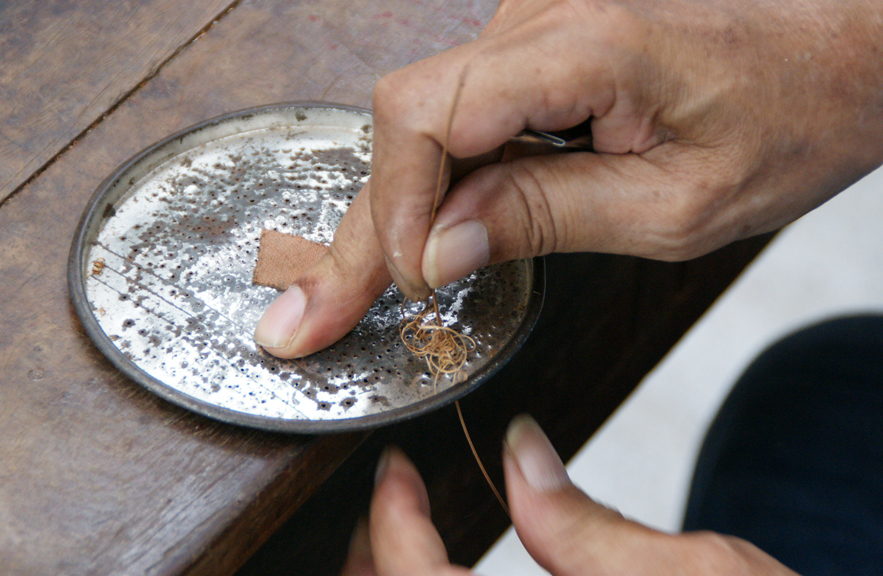 Craftsman preparing the yan li pao vine for weaving